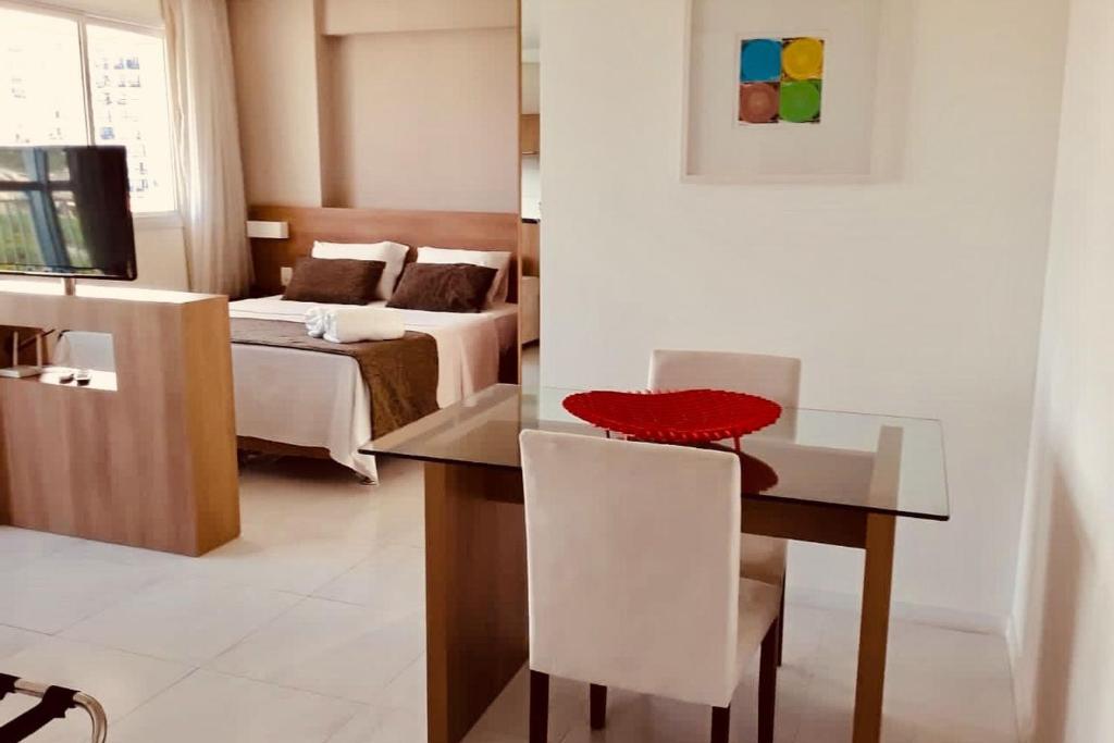 Pokój ze stołem i sypialnią z łóżkiem w obiekcie Flat TOP e PERFEITO inteiro na Barra da Tijuca com cozinha, lavanderia, GARAGEM e wi fi w mieście Rio de Janeiro