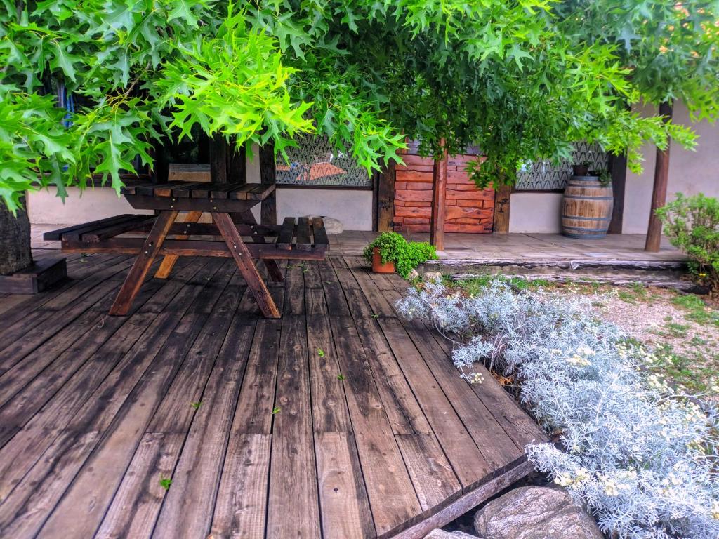 a wooden deck with a bench and some plants at La Casita Alquiler Temporario in Merlo