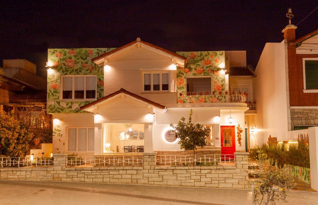 una casa blanca con una puerta roja por la noche en Allegra Dalila Casa Hotel-Arte en Tandil