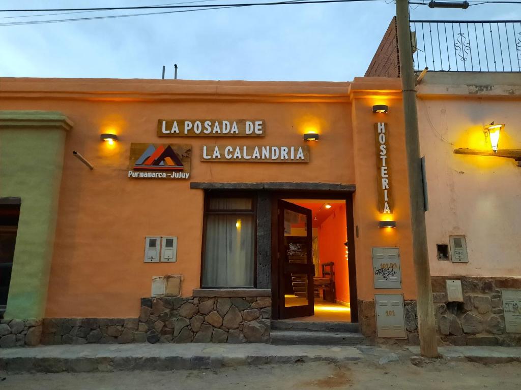 普爾馬馬卡的住宿－La Posada de la Calandria，一座有标志的建筑,上面写着读到la piscola be laçoglania的标志