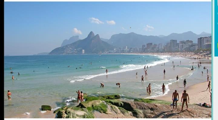 a group of people on a beach in the water at Arpoador Premium Suítes in Rio de Janeiro