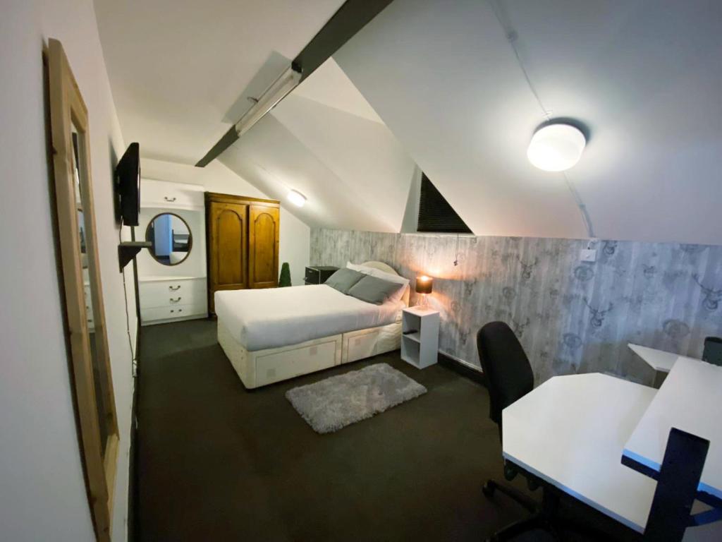 una camera con letto bianco e tavolo e sedie di Townhouse 105 a Huddersfield