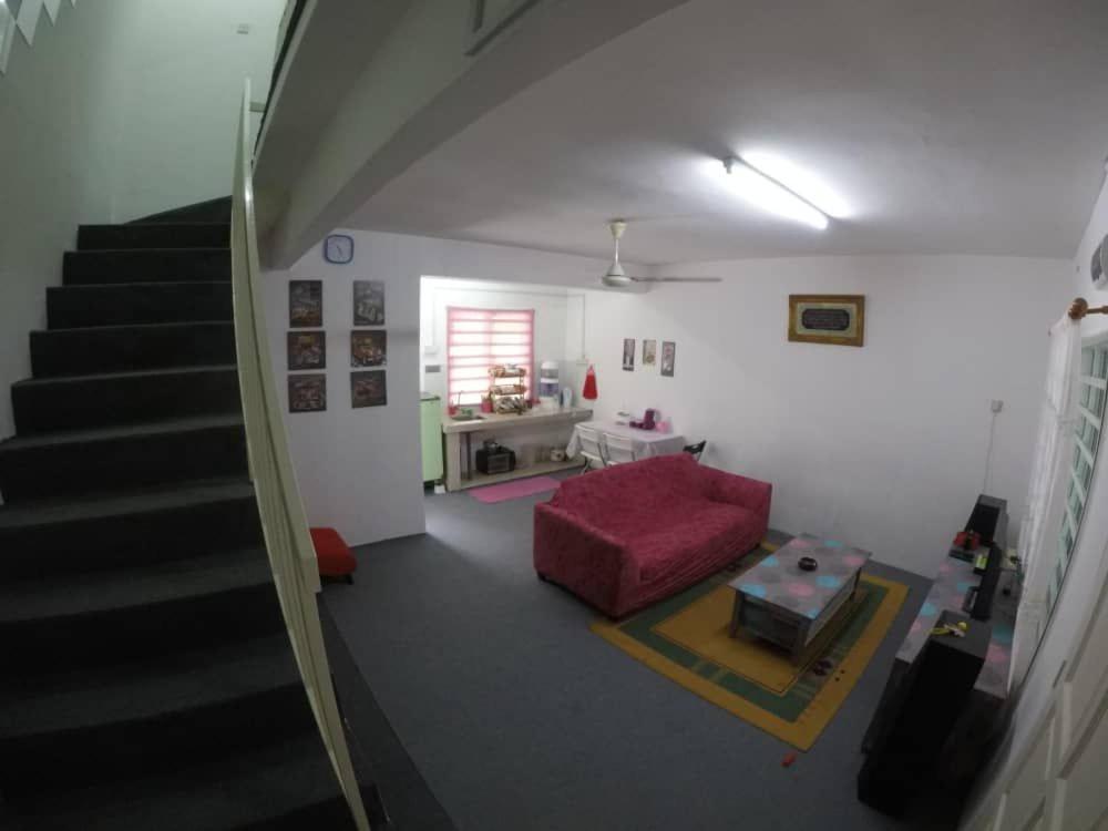 a living room with a red couch and a staircase at lost world of tambun muslim guest house in Ipoh