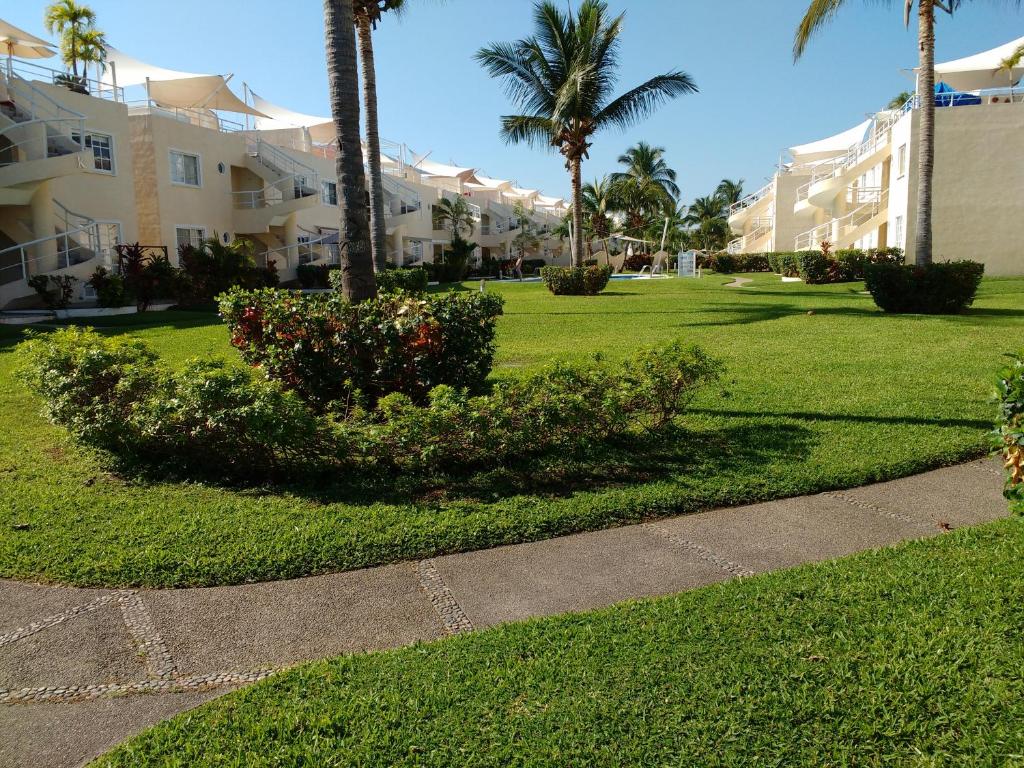 un parc avec des palmiers et un trottoir dans l'établissement Departamento en Acapulco Diamante - Puente del Mar, à Acapulco