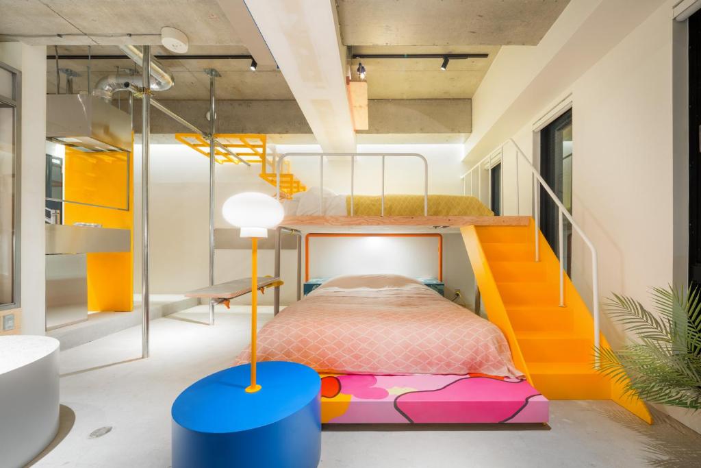 Artist Hotel - BnA STUDIO Akihabara في طوكيو: غرفة للأطفال مع سرير بطابقين والدرج