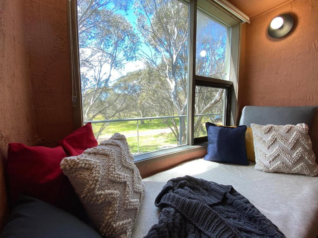 a room with a couch and a large window at Snowgums 11 in Dinner Plain