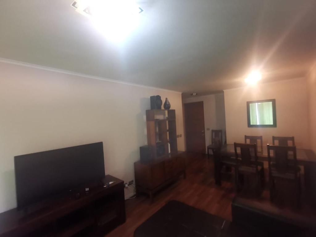 un salon avec une télévision et une salle à manger dans l'établissement Departamento Central Familiar, à Antofagasta