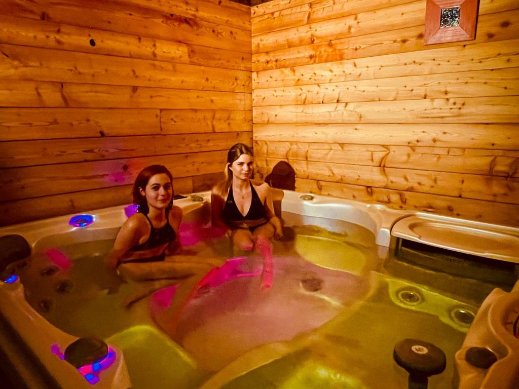 twee vrouwen in een bubbelbad in een kamer bij Chalet Alpe d'Huez 1850-Sea and Mountain Pleasure in L'Alpe-d'Huez