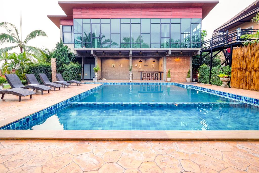 a swimming pool in front of a house at Capital O 727 Be One Resort in Ban Du