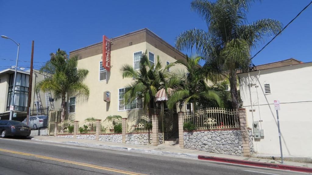 a building with palm trees in front of a street at Trylon Hotel - Hollywood in Los Angeles