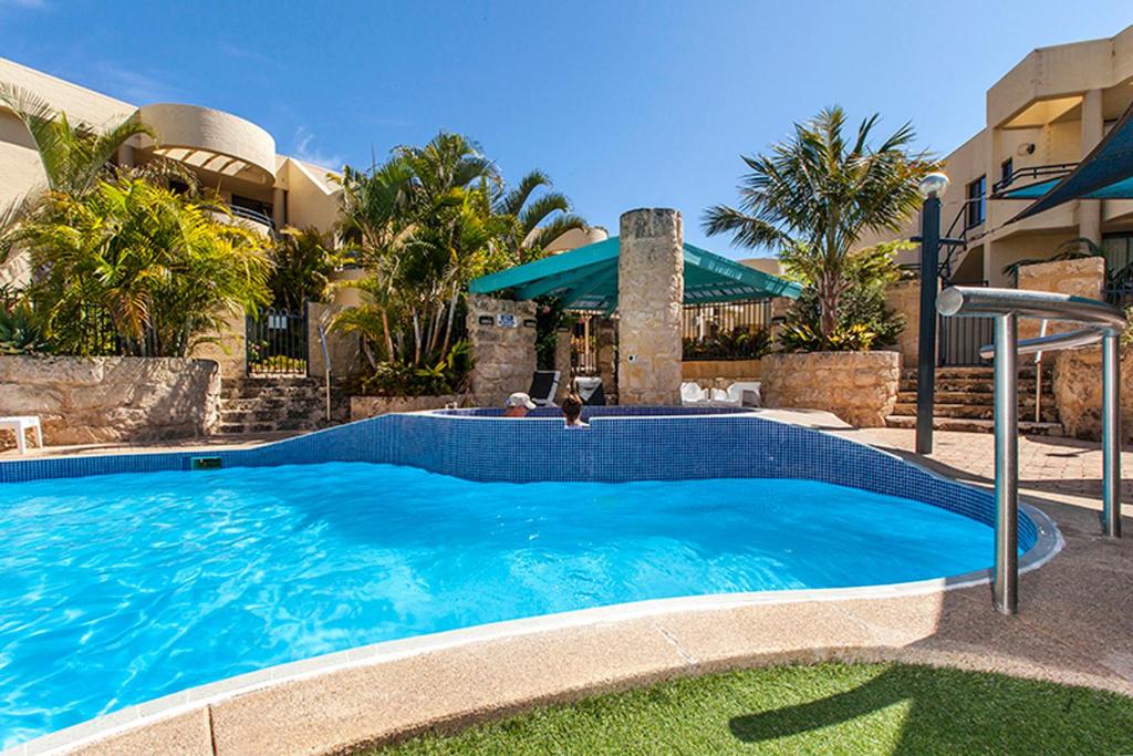 a large swimming pool in front of a house at Silver Sands Resort Mandurah in Mandurah