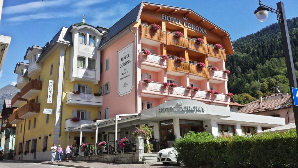 un bâtiment avec des personnes debout devant lui dans l'établissement Hotel Corona, à Pinzolo