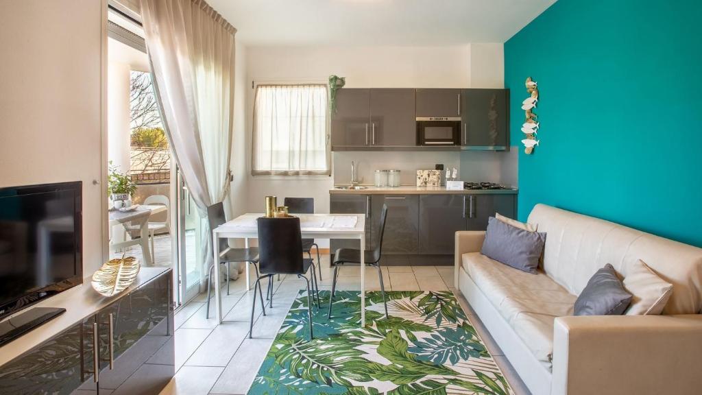 sala de estar con sofá y comedor en Residenza D-Place Ponchielli, en Riccione