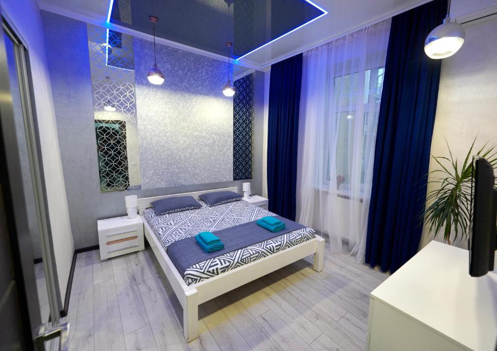 - une chambre avec un lit dans une pièce à éclairage bleu dans l'établissement Apartment with 2 bedroom near Malevich and Opera House, à Lviv