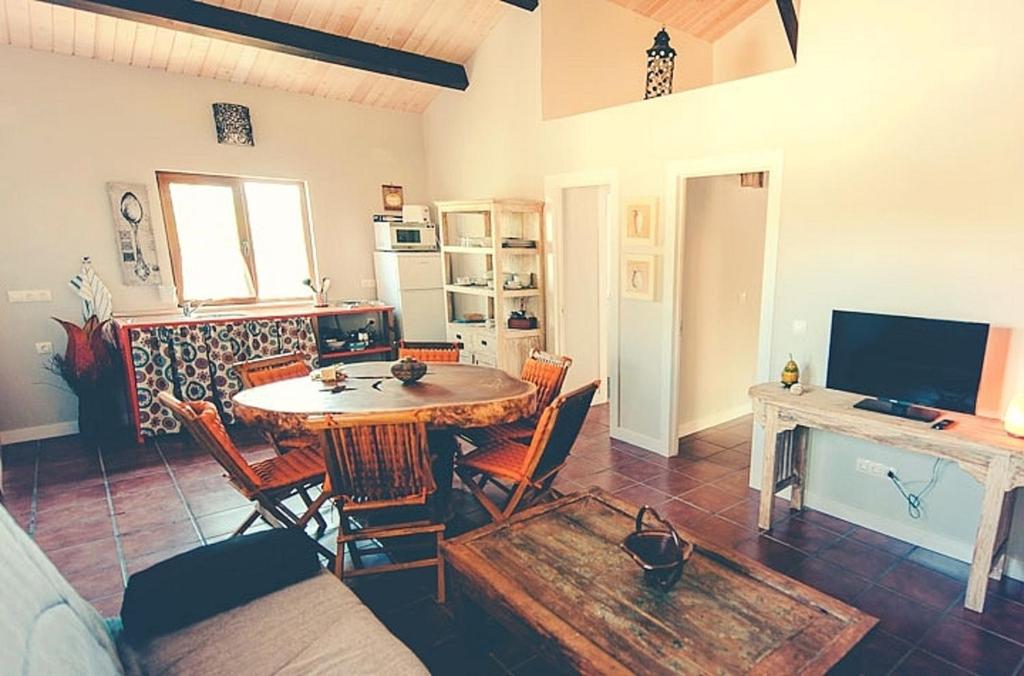 a living room with a table and chairs and a tv at 2 bedrooms house with shared pool furnished garden and wifi at Canamero in Cañamero