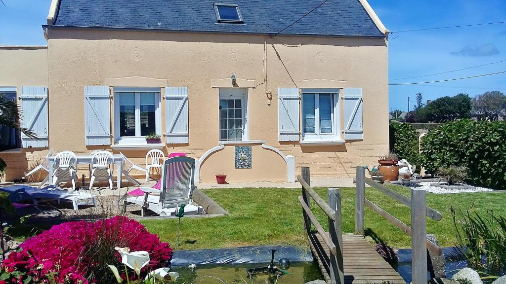 CléderにあるMaison de 4 chambres a Cleder a 500 m de la plage avec jardin clos et wifiの庭のテーブルと椅子付きの家