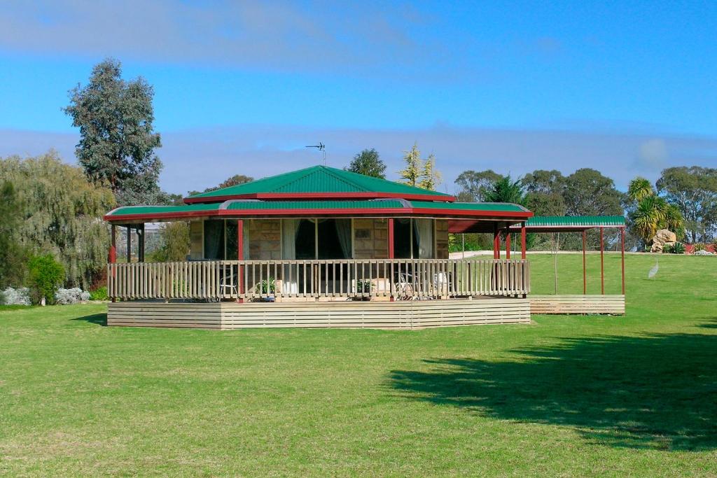 un cenador con techo verde en un campo en Carolynnes Cottages, en Naracoorte