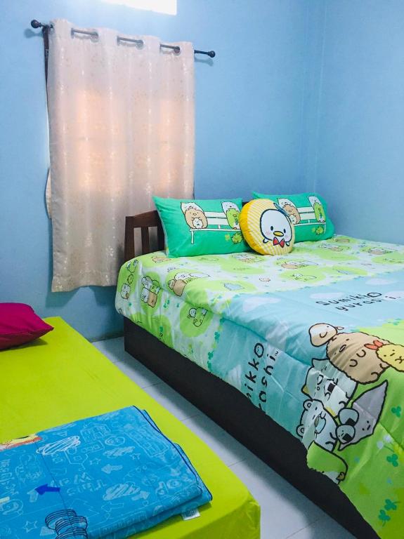 Postel nebo postele na pokoji v ubytování บ้านเรือนทอง