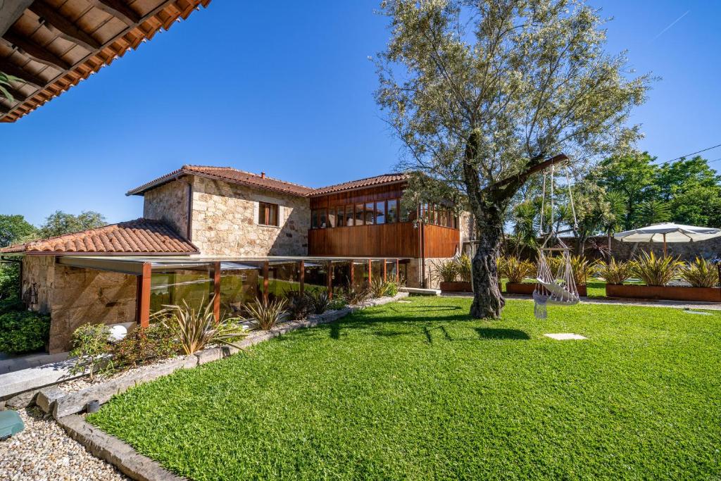 a house with a tree in the yard at Luxurious House in Braga with Pool in Barreiros