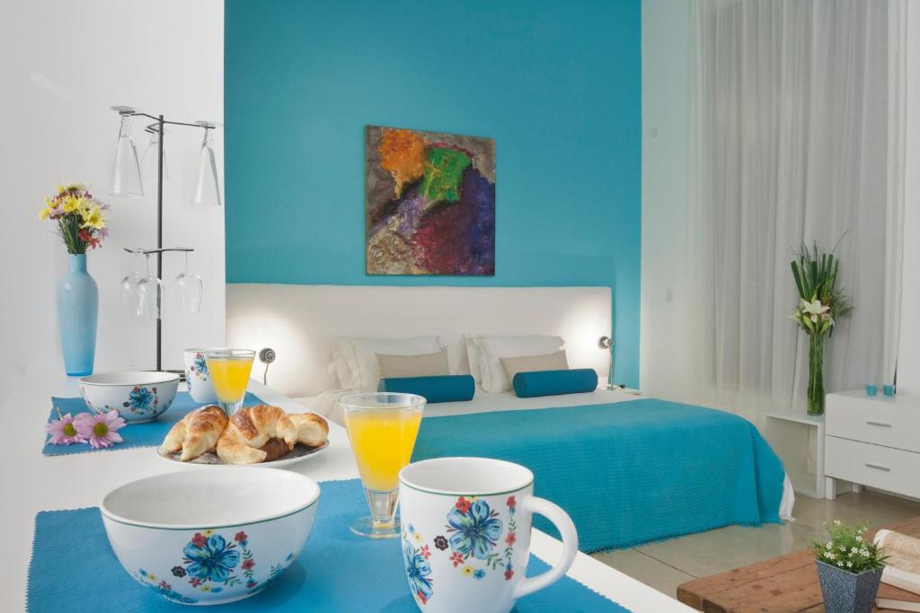 - une chambre bleue avec un lit et une table avec des tasses dans l'établissement Soho Point, à Buenos Aires