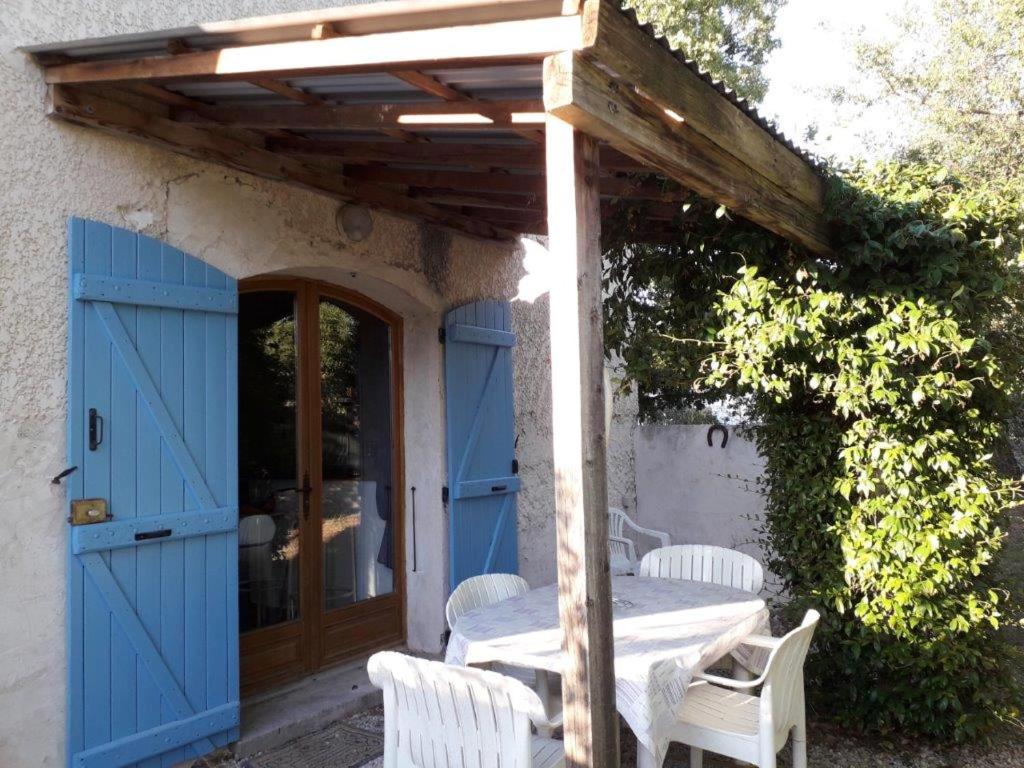 a patio with a blue door and a table and chairs at Appartement d'une chambre avec piscine partagee jardin clos et wifi a Le Luc in Le Luc