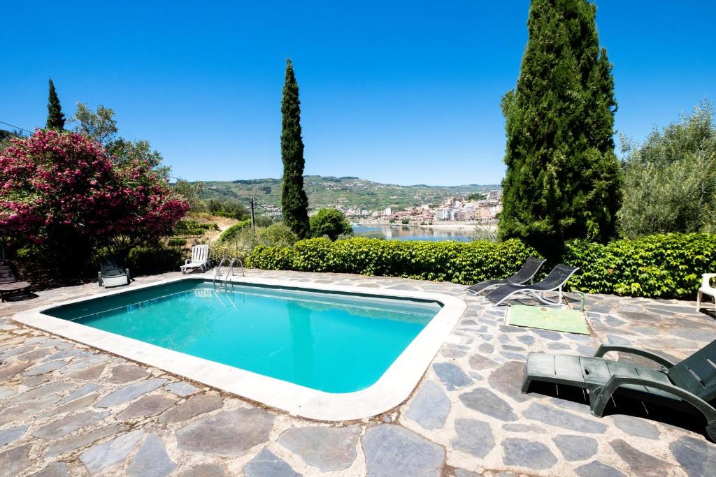 a swimming pool in a patio with chairs and trees at Charming Villa with Private Pool in Lamego in Lamego