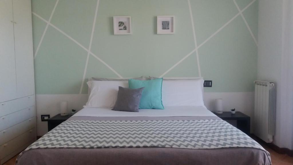 - une chambre avec un grand lit et des oreillers bleus dans l'établissement Alloggio turistico a Giardino di Roma, à Rome