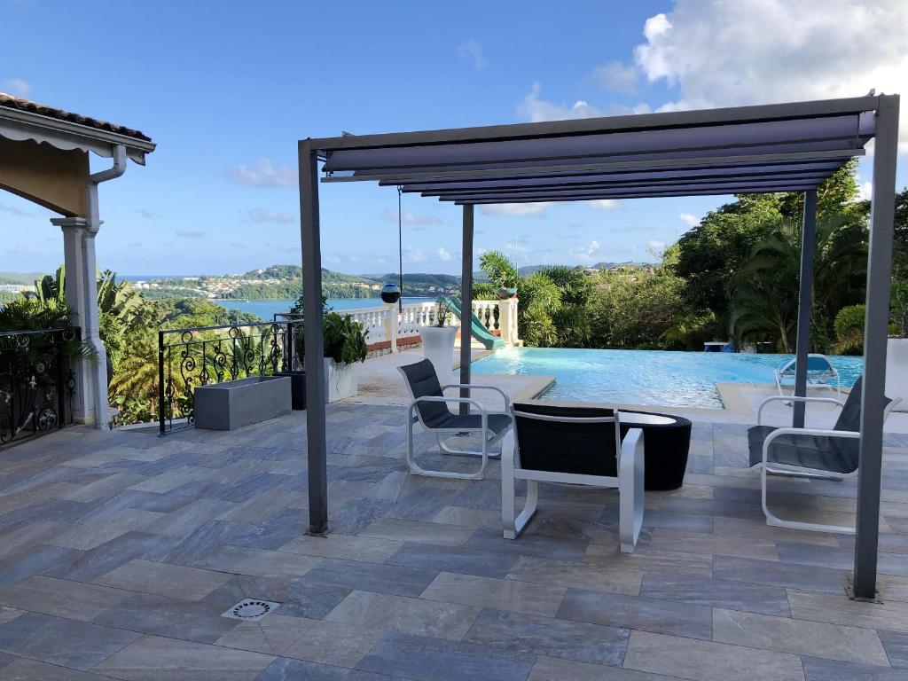een patio met stoelen en een zwembad bij Maison de 2 chambres avec vue sur la mer piscine partagee et jardin clos a La Trinite a 2 km de la plage in La Trinité