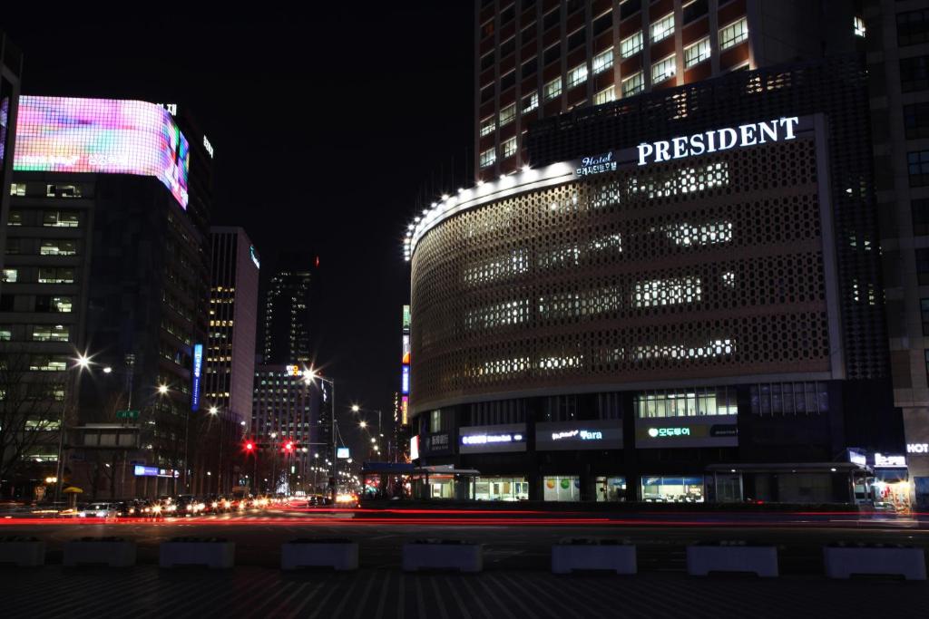 um edifício alto numa cidade à noite em Hotel President em Seul
