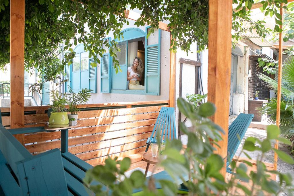 a woman is looking out the window of a house at Zimeroni in Zikhron Ya‘aqov