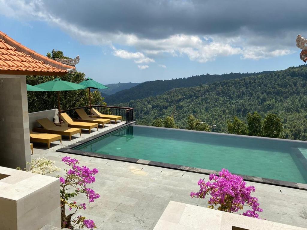 a swimming pool with a view of a mountain at Munduk Sari Resort in Munduk