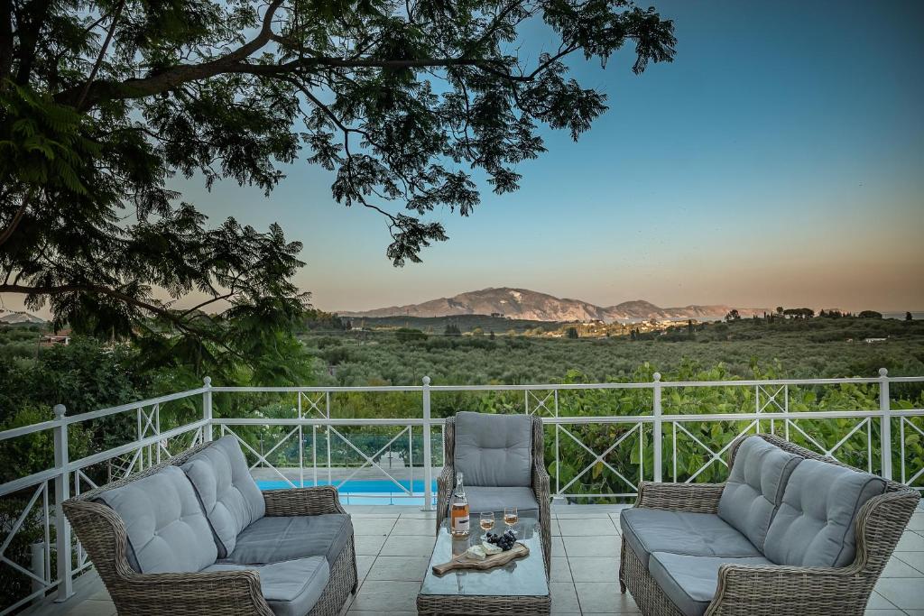 a patio with two couches and a table with a view at Villa Natura prive swimming pool in Lithakia