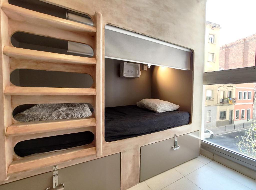 Habitación pequeña con cama y ventana en Onefam Sants, en Barcelona