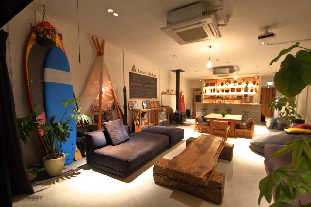 a living room with a couch and a surfboard at guest house Active Life -YADO- in Ishinomaki