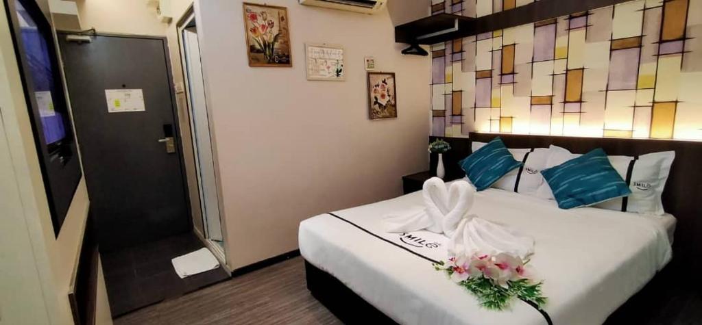 a hotel room with a bed with flowers on it at Smile Hotel Cheras Pudu KL in Kuala Lumpur