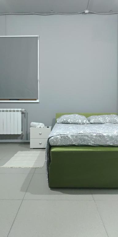 Schlafzimmer mit einem Bett und einem Flachbild-TV in der Unterkunft Мини-отель "Every Day" in Krasnojarsk