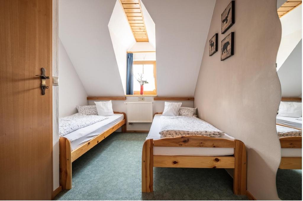 two beds in a room with two windows at Ferienhäuser zur Schäferei in Mitwitz