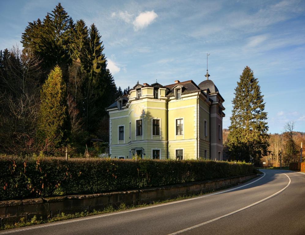 ein großes weißes Haus am Straßenrand in der Unterkunft Penzion Vila Julie in Jilemnice