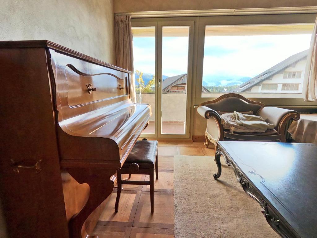 - un salon avec un piano et un canapé dans l'établissement Beautiful apartment over the mountain, à Crans-Montana