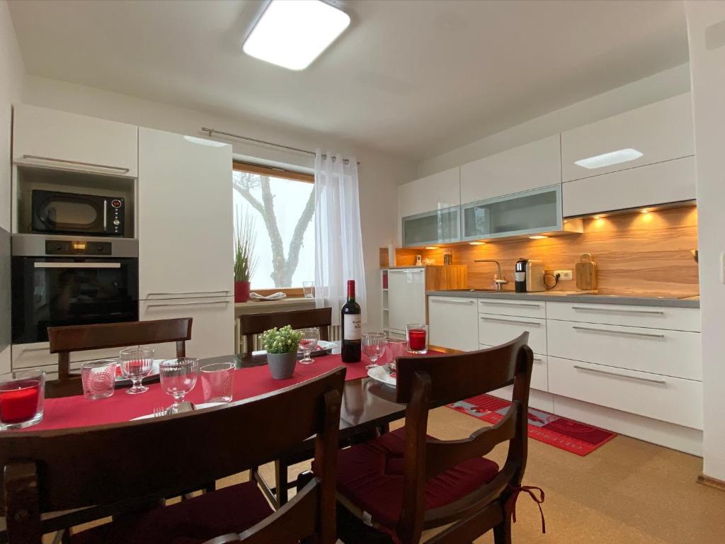 una cocina con una mesa con copas de vino. en MITTEN im BAYERISCHEN WALD-95m² Wohnung + *NETFLIX* Direkt am Skilift! en Schöfweg