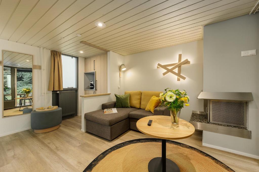 a living room with a couch and a table at Hotel Eemhof by Center Parcs in Zeewolde