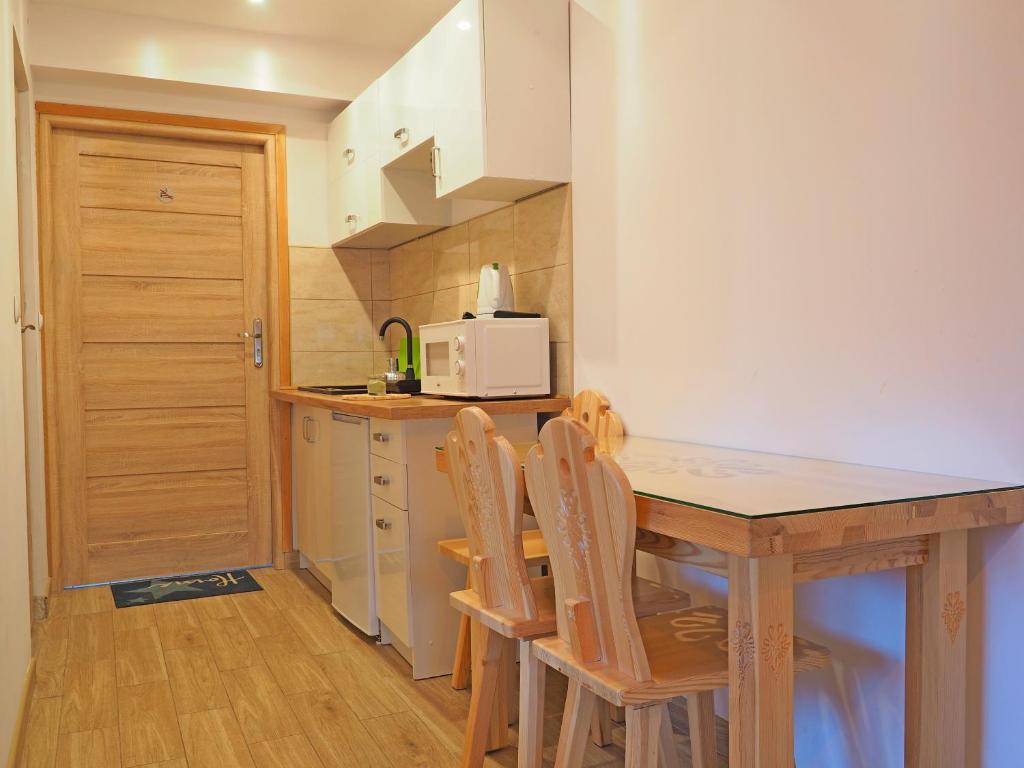 a kitchen with a wooden table and chairs at Pokoje gościnne u Basi in Zakopane