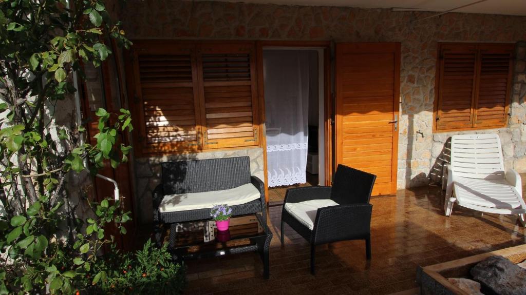 een patio met een bank, een stoel en een tafel bij Apartments Duda in Malinska