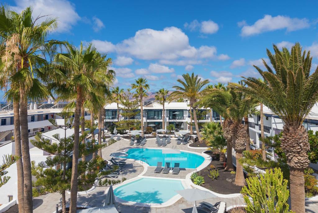 una vista aérea del complejo con palmeras y una piscina en Apartamentos Playamar, en Puerto del Carmen