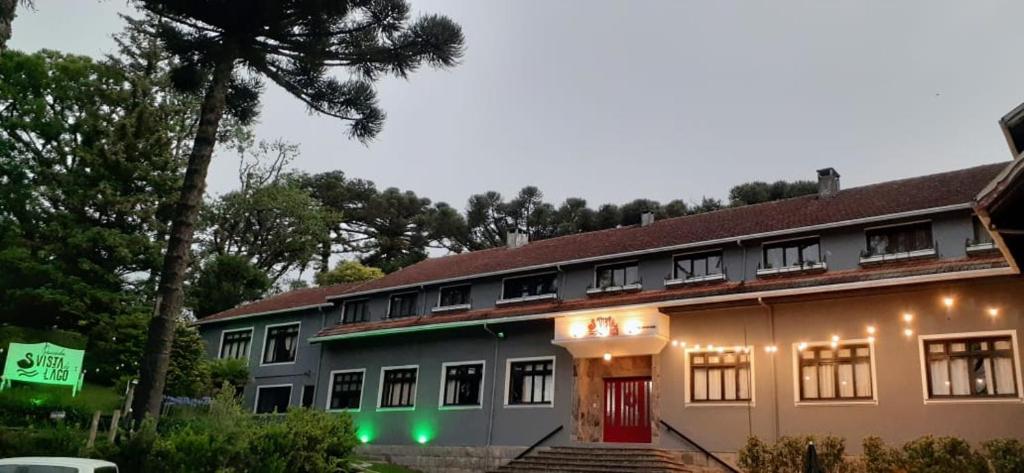 un edificio con luces verdes en el lateral. en Pousada Vista do Lago - HOSTEL, en Gramado
