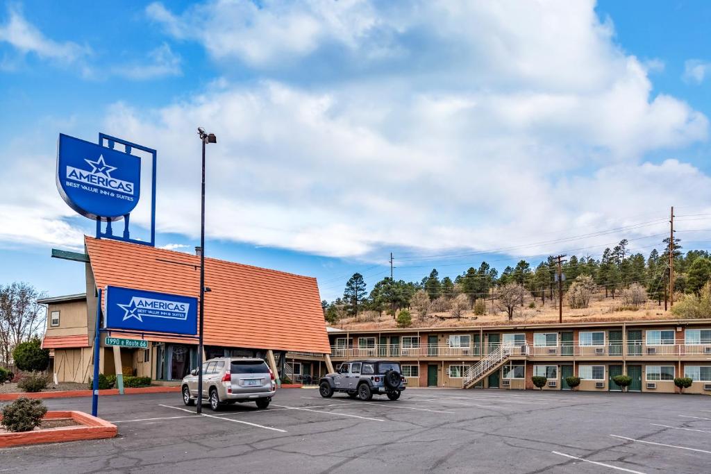 Americas Best Value Inn and Suites Flagstaff في فلاغستاف: فندق فيه سيارات متوقفة في مواقف