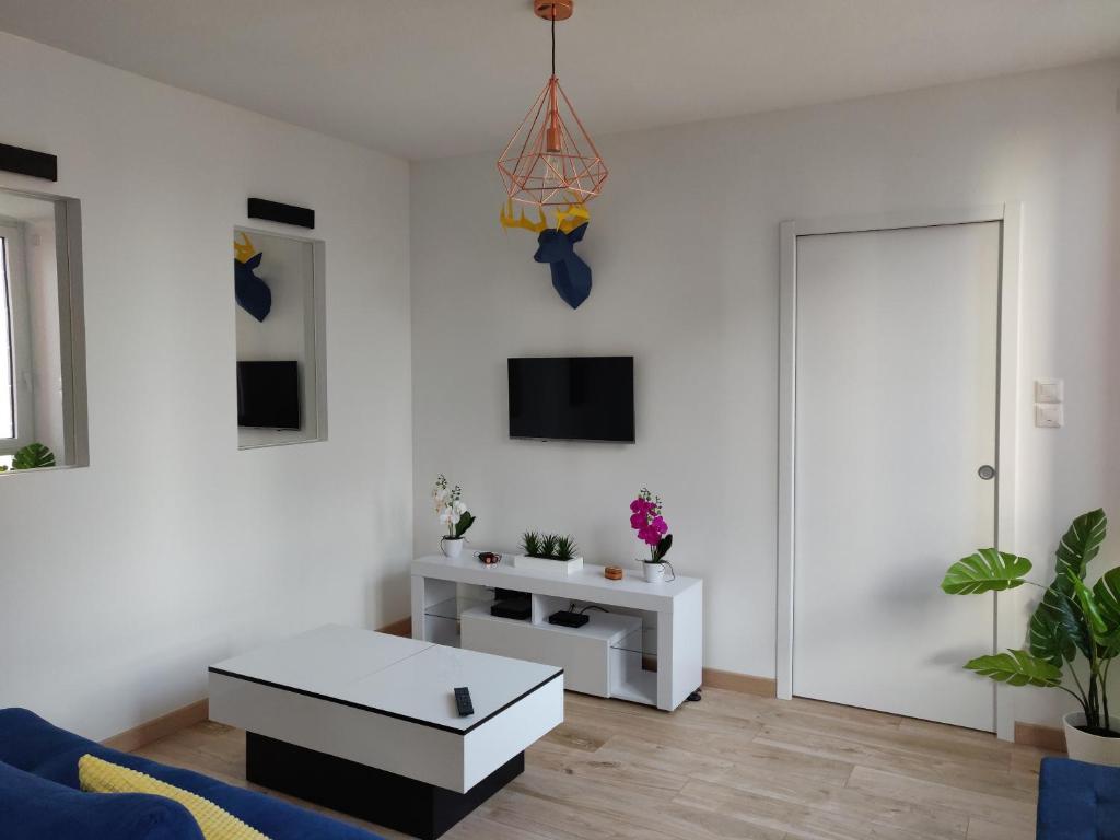 - un salon blanc avec un canapé bleu et une table dans l'établissement T2 Lounge & Design - Toulouse Centre Ramblas, à Toulouse