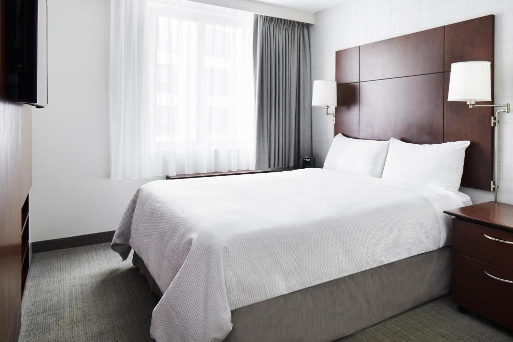 ein Hotelzimmer mit einem großen Bett und einem Fenster in der Unterkunft Club Quarters Hotel Embarcadero, San Francisco in San Francisco