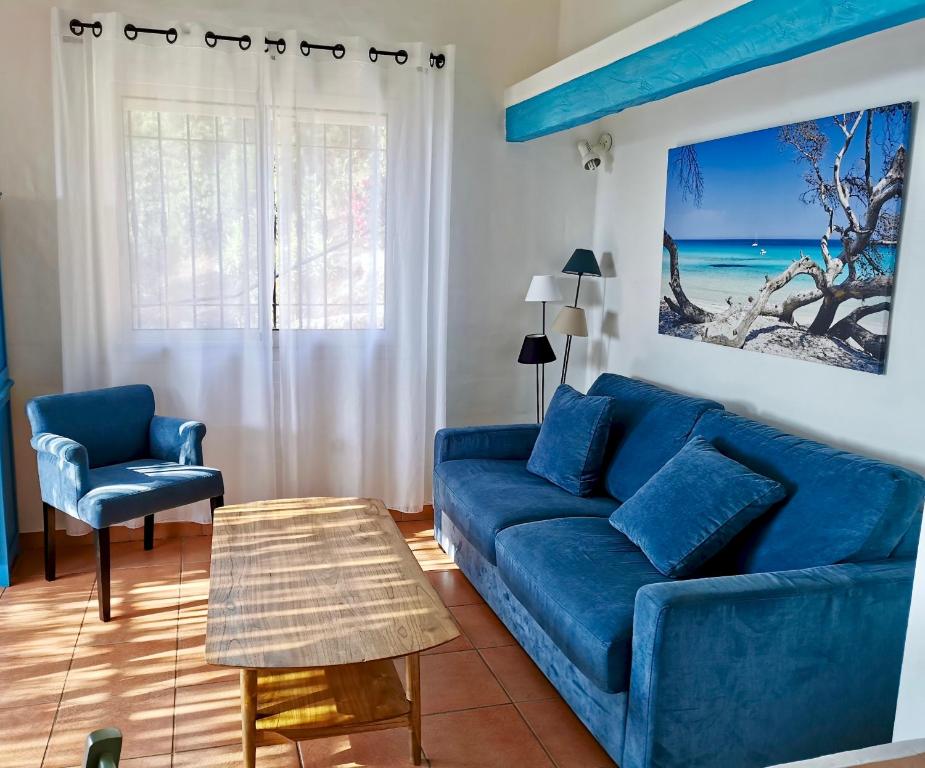 a blue couch and a chair in a living room at Résidence Belvedere de Palombaggia in Porto-Vecchio