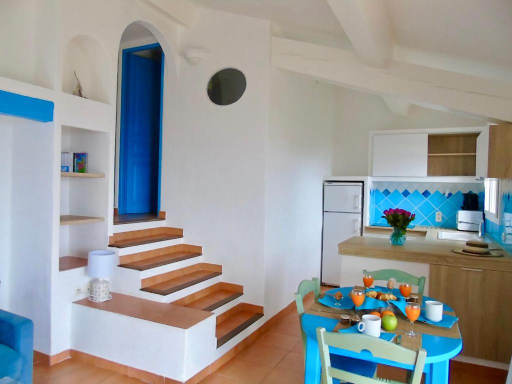 a kitchen with a table and a staircase in a room at Résidence Belvedere de Palombaggia in Porto-Vecchio